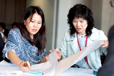 Two women work together at the AEF conference