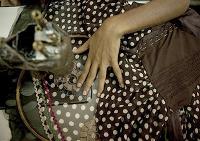 Woman sits sowing at a garment factory in Delhi