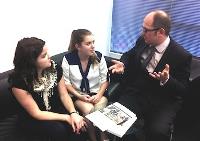 Man explains something using hand gestures to two young girls