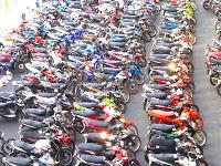 Hundreds of motorcycles all parked closely together in a parking lot