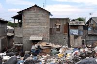 Brick and cement homes next to a rubbish pile