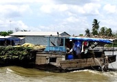 A boat loaded with crops for trade on the Mekong River, Vietnam