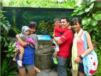 Devon's family surrounded by greenery with his sister, cousin, father and mother.