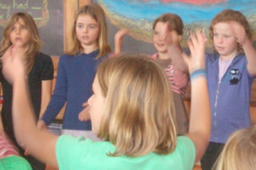 A group of children stand in a circle and play a game