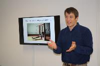 Asia Literacy Ambassador Dan Ednie-Lockett stands in front of screen speaking