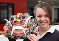 Student holding up Indonesian mask