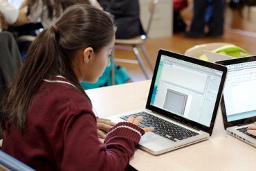 A girl works at her laptop computer