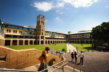 Students and teachers walk around the gardens of a University
