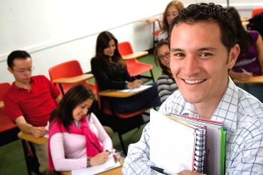 A man stands in front of a group of students at desks